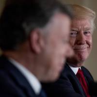 President Donald Trump listens to Colombian President Juan Manuel Santos during a news conference in the East Room of the White House on May 18. Trump threatens Colombia over record cocaine production