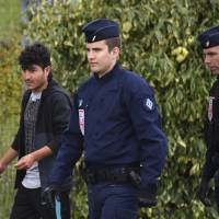 French police officers evacuate migrants from a makeshift camp in Grand-Synthe, near Dunkirk, northern France, Tuesday. The prefecture of the Nord region said that 240 people had been evacuated from the camp so far, and the operation was continuing. 557 migrants 'living in mud' in makeshift camp near Dunkirk evacuated by French police