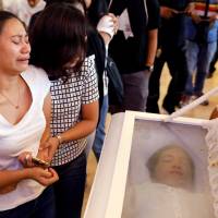 Mourners weep during the funeral of 19-year-old Carl Angelo Arnaiz, accused of robbery and shot dead by police, in Pateros, Metro Manila, Tuesday. Duterte tells police to let media go on drug raids in bid to disprove extrajudicial killings