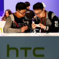 Attendees at the Mobile World Congress view the new HTC U Ultra in Barcelona, Spain, on March 1. Google buys part of HTC for $1.1 billion in bid to compete with Apple and Amazon on devices