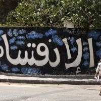 A Palestinian man and his daughter walk past graffiti reading in Arabic “Division” in Gaza City on Sunday, after Hamas announced it had agreed to steps toward resolving a decade-long split with the Fatah movement and was ready to hold elections. Hamas said it had agreed to key demands made by Fatah: dissolving the so-called administrative committee, while saying it was ready for elections and negotiations toward a unity government. Hamas agrees to dissolve its Gaza administration, push for Palestinian unity government