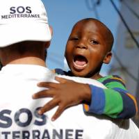 A member of the crew of the SOS Mediterranee organization plays with a child on the MV Aquarius after rescuing a group of migrants during a search and rescue (SAR) operation in the Mediterranean Sea, off the Libyan Coast, Friday. Libya reports rescuing over 3,000 migrants in week from Mediterranean