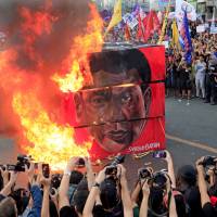 Protesters burn a cube effigy with a face of President Rodrigo Duterte during a National Day of Protest outside the presidential palace in metro Manila Thursday. Manila protesters slam martial law, police killings, say Duterte using 'Marcos's playbook of repression'