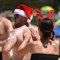 A woman applies suntan lotion to a man at Sydney’s Bondi Beach on Christmas Day last year. Researchers say a combination of new treatments can stop the world’s deadliest form of skin cancer — melanoma — in its tracks and halt its spread to other organs. Australian researchers say combination of treatments can stop melanoma from spreading