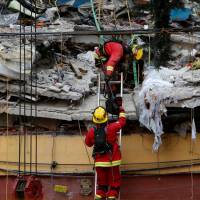 Rescue team members work on the rubble of a collapsed building after an earthquake hit Mexico City, Wednesday. Rescuers pull girl alive from collapsed school amid frantic search as Mexico quake toll climbs to 225