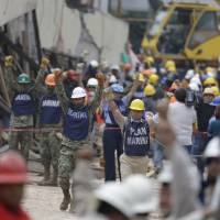Soldiers hold up closed fists motioning for silence during rescue efforts at the Enrique Rebsamen school in Mexico City Thursday. Mexicans transfixed by efforts to rescue girl from quake-flattened school, only to learn she didn't exist
