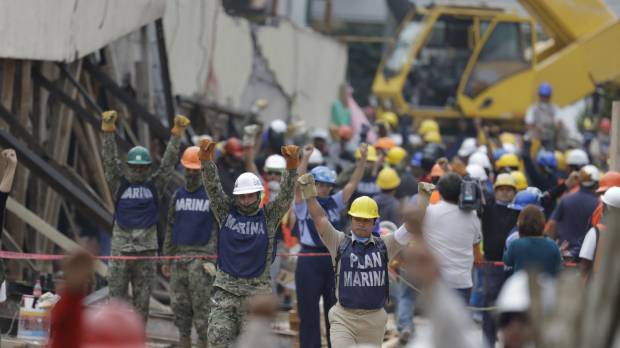 Soldiers hold up closed fists motioning for silence during rescue efforts at the Enrique Rebsamen school in Mexico City Thursday. Mexicans transfixed by efforts to rescue girl from quake-flattened school, only to learn she didn't exist