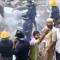 People and rescue personnel are seen after a building collapsed in Mumbai in this still frame taken from video Thursday. Rain-weakened Mumbai building collapses, leaving 19 dead, over dozen missing