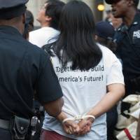 A protester is arrested for blocking traffic at the Brooklyn Bridge at a rally to defend DACA on Tuesday in New York. Obama calls ending DACA 'cruel,' 'self-defeating' and urges Congress to remedy the plight of the targeted