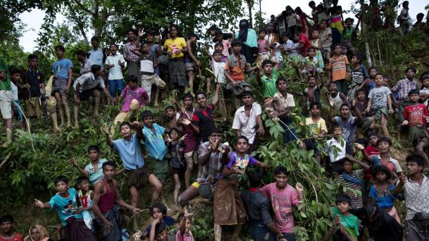 Rohingya stretch their arms out for food being distributed near the Balukhali refugee camp in Cox’s Bazar, Bangladesh, on Wednesday. Buddhist protesters try to block aid shipment to Myanmar's Muslim Rohingya