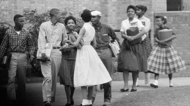 In this Oct. 2, 1957, photo, the first black students to enroll at Central High School in Little Rock, Arkansas, leave the building and walk toward a waiting Army station wagon following their classes. Monday, marks the 60th anniversary of when nine black students enrolled at the Arkansas school. One of the nine students is obscured by another student in this photograph. Segregation still in U.S. schools 60 years after landmark ruling, 'Little Rock Nine'