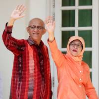 Singapore’s ex-speaker of parliament, Halimah Yacob, arrives with her husband to submit her presidential nomination papers in the city-state Wednesday. Singapore gets first female president, but without a vote
