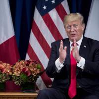 French President Emmanuel Macron listens as U.S. leader Donald Trump speaks about the Bastille Day Parade before a meeting at the Palace Hotel during the 72nd session of the United Nations General Assembly on Monday in New York. Trump mulls Washington parade to showcase 'military might' on Independence Day