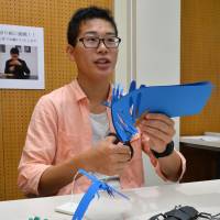 Shinichiro Ishikawa creates a paper cutout of an insect at the Nagoya University Museum. Nagoya teen brings 100 paper insects to life at an art exhibit
