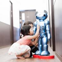 Children play with Vevo, a robot co-developed by Global Bridge Holdings and academics at Gunma University, at a nursery school run by the company in Chiba Prefecture on June 9. Day care facilities test robots as high-tech solution to alleviate staffing shortages