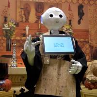 Pepper, the humanoid robot created by SoftBank Robotics, recites Buddhist sutras during the Life Ending Industry Expo 2017 in Tokyo on Aug. 23. High tech, IT and robots are at forefront of Japan's funeral industry boom