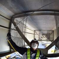 A worker from Shutoko Engineering checks a joint on a steel frame under an expressway in Tokyo on June 5. 'Highway doctor' taps 3-D tech to diagnose Tokyo's aging expressways