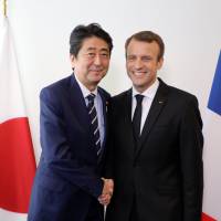 French President Emmanuel Macron greets Prime Minister Shinzo Abe Wednesday at the U.N. headquarters in New York. Abe, Macron agree to pursure further security cooperation, rule of law at sea