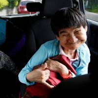 Congenital Minamata disease patient Shinobu Sakamoto, 61, and her mother, Fujie, sit in a car as they head for a hospital in Minamata, Kumamoto Prefecture, on Sept. 14. Minamata disease victims' voices dim with age but still cry for recognition