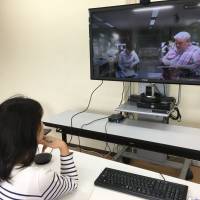 The writer holds a meeting with colleagues in Tokyo using the teleconferencing system at a working space in the town of Shari, Hokkaido, on Aug. 11. Hokkaido 'workations' breathe fresh air into telecommuting