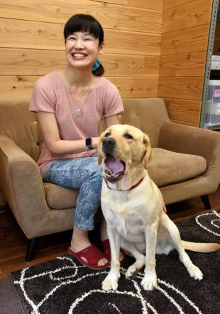 Kanako Suzuki sits with her guide dog, Ariel, in August.
