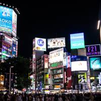 Prominent placement: A billboard promoting emerging artist Daoko (top left) overlooks a busy Shibuya Crossing in early September. AKB48 sets a chart record, but Daoko and Kenshi Yonezu are playing the long game