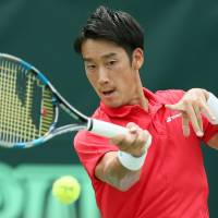 Yuichi Sugita hits the ball to Guilherme Clezar during Japan’s Davis Cup World Group playoff against Brazil in Osaka on Friday. Sugita won 6-2, 7-5, 7-6. Sugita, Soeda give Japan strong start against Brazil in Davis Cup World Group playoff