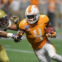 Tennessee running back John Kelly scores agame-tying touchdown in the fourth quarter against Georgia Tech on Monday in Atlanta. Kelly had two more rushing touchdowns after that as the Volunteers won 42-41 in double overtime. Tennessee overcomes Georgia Tech in double overtime