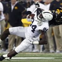 Penn State receiver Juwan Johnson is tackled by Iowa’s Joshua Jackson during the first half on Saturday night in Iowa City. Penn State won 21-19. No. 4 Penn State beats Iowa with TD on final play