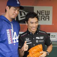 Takuma Sato (right) poses for a photo with Los Angeles Dodgers pitcher Kenta Maeda on Sept. 13 in San Francisco. Indy 500 winner Sato to drive for Rahal in 2018