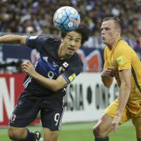 Japan’s Shinji Okazaki (left) and Australia’s Brad Smith vie for the ball during their World Cup qualifier on Thursday in Saitama. Okazaki cautions Japan against complacency