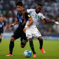 Japan’s Hiroki Sakai (left) vies with Saudi Arabia’s Fahad Al Muwallad during their World Cup qualifier in Jeddah on Tuesday. Japan loses to Saudi Arabia in final World Cup qualifier