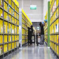 Employees pack orders at Amazon.com Inc.’s Amazon Prime Now fulfillment center in Singapore, in July. Amazon faces challenges in a shopper-friendly Singapore full of malls, Alibaba presence