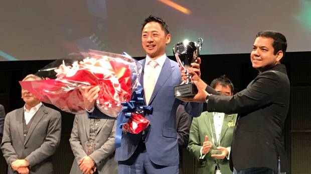 Seven Dreamers Laboratories Inc. CEO Shin Sakane (left) receives a trophy from Fenox Venture Capital CEO Anis Uzzaman after winning Japan’s preliminary round of the Startup World Cup on Wednesday. Laundry-folding robot maker will represent Japan at startup competition