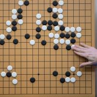 A commentator in a media room positions pieces forming a replica of a game between go player Lee Se-Dol and Google-developed AlphaGo in Seoul on March 13, 2016. Newest version of self-taught, 'superhuman' AI now even smarter: makers