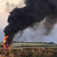 A black smoke rises from a U.S. Marine CH-53 helicopter that was forced to land Wednesday evening in the village of Higashi, Okinawa Prefecture. U.S. military chopper bursts into flames in Japan