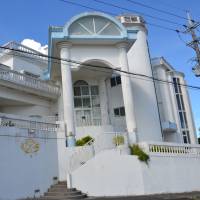 Hotel Sha La La, located amid fields of chrysanthemums grown through light cultivation, attracts inbound tourists with its castle-like exterior. Okinawa innkeeper transforms 'love hotel' into castle with a floral view