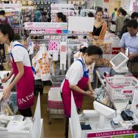 Employees work checkout counters at a Daiso store, operated by Daiso Sangyo Corp., in Tokyo in June. How Japan's service industry is trying to adapt to the worst labor crunch in 25 years