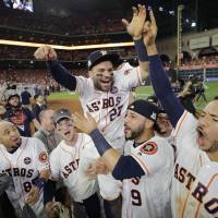 The Astros’ Jose Altuve is carried by his teammates after their win over the Yankees in Game 7 of the ALCS in Houston on Saturday. Astros get past Yankees to reach World Series