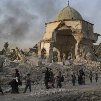 Fleeing Iraqi civilians walk past the heavily damaged al-Nuri mosque as Iraqi forces continue their advance against Islamic State militants in the Old City of Mosul, Iraq, in July. A new United Nations report published Thursday has found that the Islamic State group committed serious “international crimes” such as using civilians as human shields during the Iraqi military’s nine-month campaign to liberate the city of Mosul. Iraq not equipped to try Islamic State over atrocities in Mosul, against Yazidis: U.N.