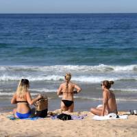 Beachgoers spend their afternoon at Manly Beach in Sydney in September. Australia sweltered through its third-hottest year on record in 2017. Warming set to breach Paris accord's toughest limit by middle of century, draft report says