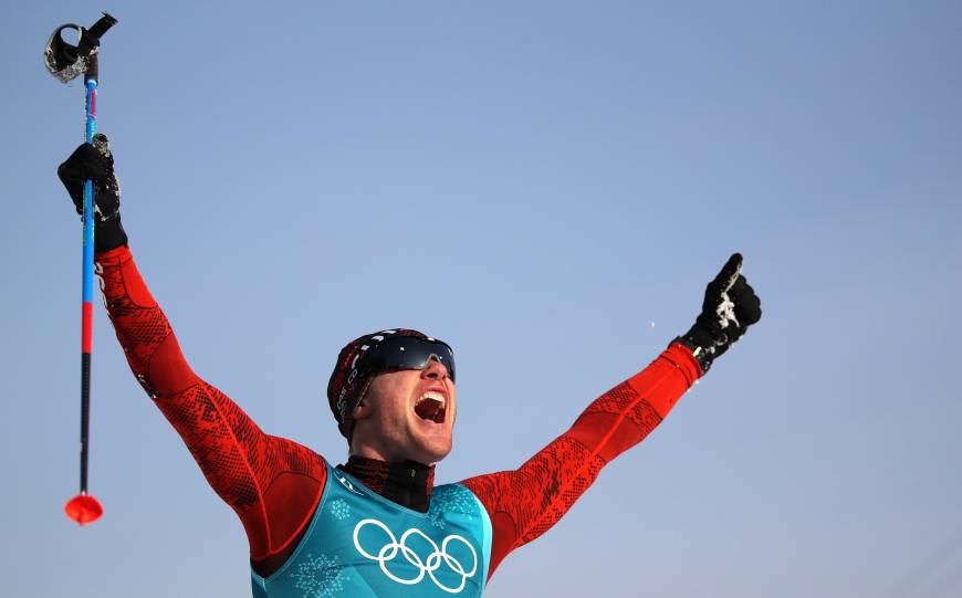 Dario Cologna of Switzerland celebrates after winning his third straight Olympic gold medal in the men