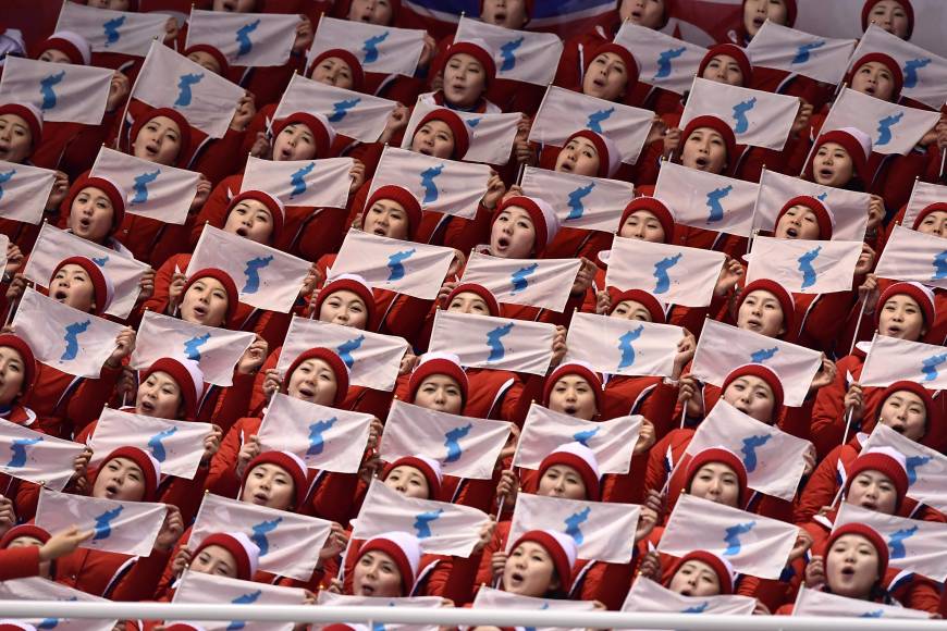 North Korean cheerleaders hold unification flags as they attend the pair skating free skating of the figure skating event on Friday.