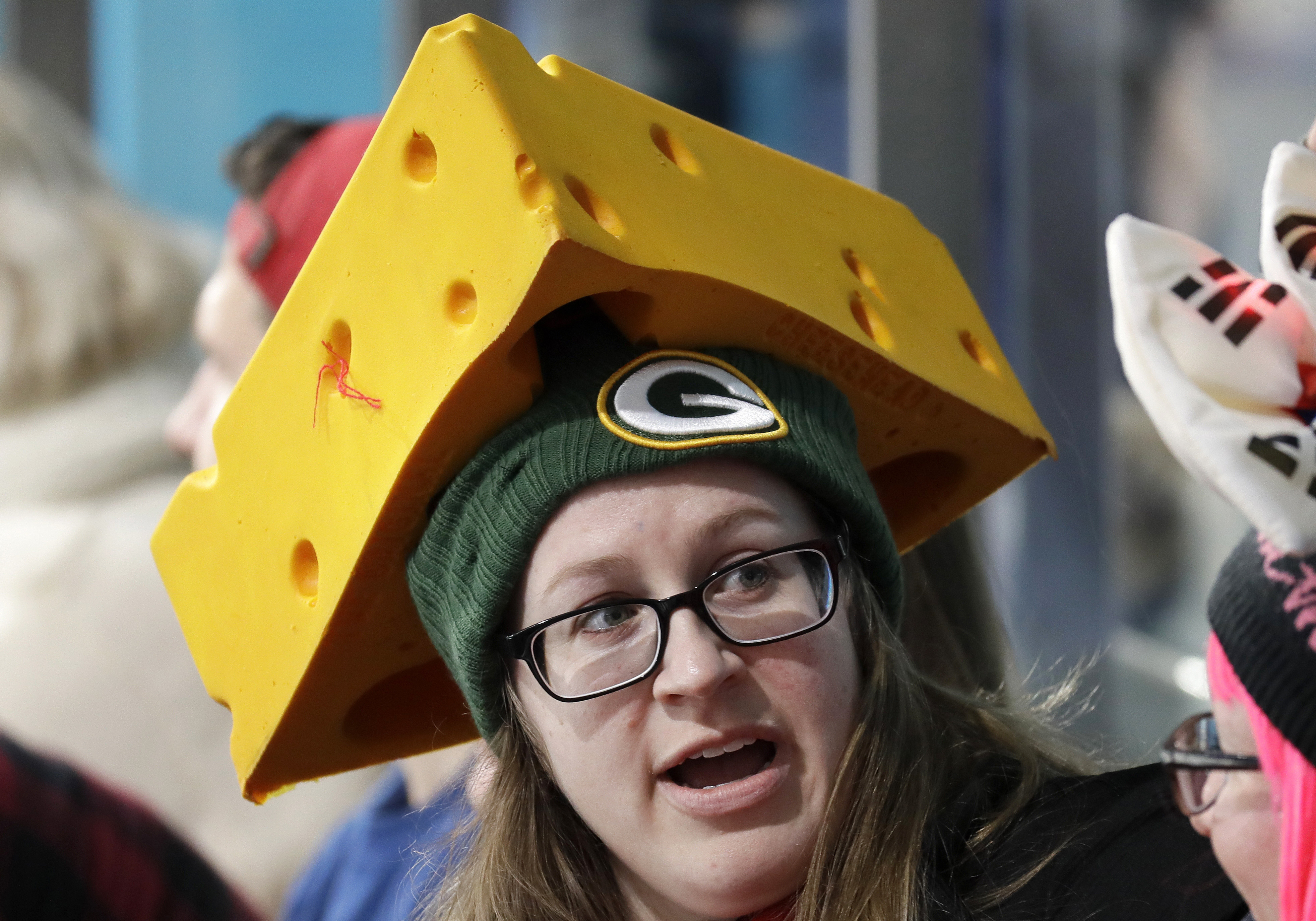 A spectator wears a Green Bay Packers cheese hat during the men