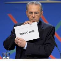 Then-International Olympic Committee President Jacques Rogge shows off the card displaying Tokyo after the city was elected host of the 2020 Summer Games during an IOC session in Buenos Aires in September 2013. Tarnished? The Olympic brand still mints money like never before
