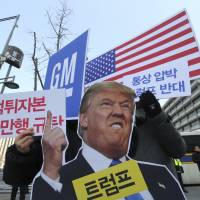 South Koreans protest GM Korea’s restructuring near the U.S. Embassy in Seoul on Tuesday. The signs read, “We oppose Trump’s trade pressure and denounced GM’s brutality.” Distrust of unions and GM hangs over South Korean efforts to stem job losses