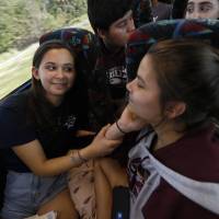 Julia Salomone, 18 (left), and her sister, Lindsey Salomone, 15, student survivors from Marjory Stoneman Douglas High School, where 17 students and faculty were killed in a mass shooting on Wednesday, talk aboard their bus between Parkland, Florida, and Tallahassee Tuesday to rally outside the state capitol and talk to legislators about gun control reform. Students who survived Florida mass shooting on collision course with lawmakers over guns