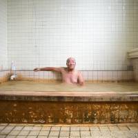 A man bathes in the Tsukano hot spring in the city of Oita. He says he visits the spring and drinks its water after bathing every day. Pharmacists in Oita make guidebook to drinkable hot springs water