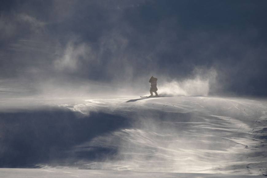 A crew member skis slowly down the slopes after the women