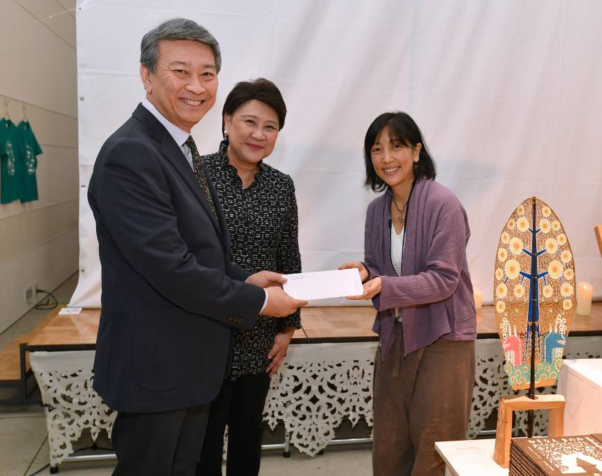 Natori receives a donation on behalf of Ban Rom Sai, a safe haven for children infected with AIDs that was established in Chiang Mai, Thailand, in 1999.